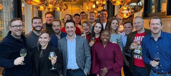 Professionals in smart casual attire gather indoors, networking at a governance, legal, and compliance recruitment event.