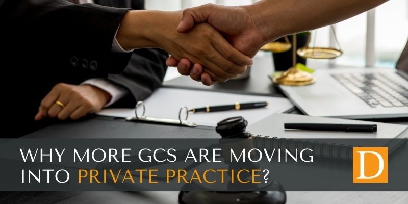 Two professionals shake hands over a desk featuring legal scales and a gavel, symbolising Danos Group’s expert legal and compliance recruitment solutions, with overlaid text asking: Why are more GCs moving into private practice?.
